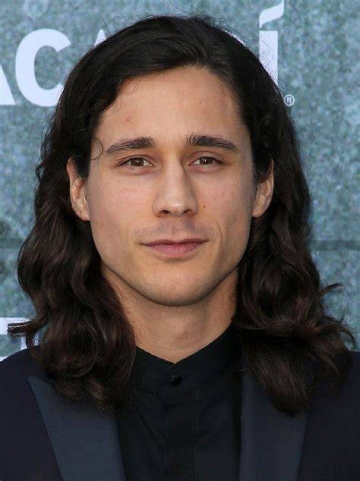 Peter Gadiot looking handsome in white t-shirt with black glasses.
