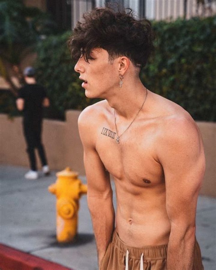 Tayler Holder going shirtless in a field.